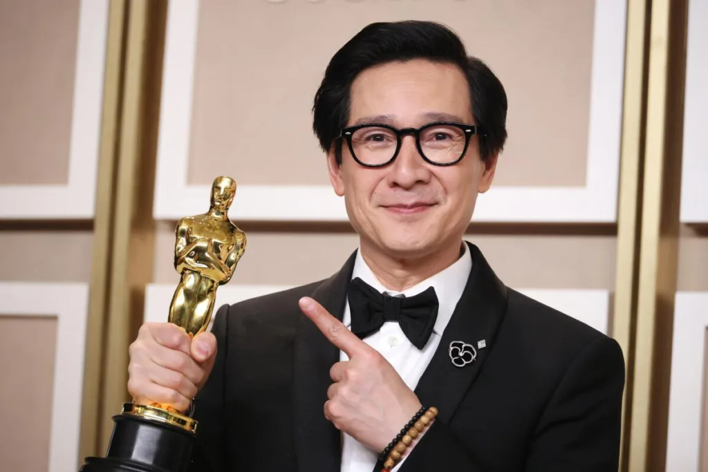 Image of Ke Huy Quan with an Oscar award in right hand